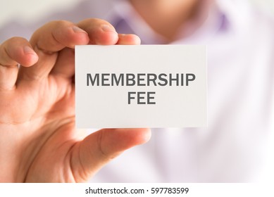 Closeup on businessman holding a card with MEMBERSHIP FEE message, business concept image with soft focus background