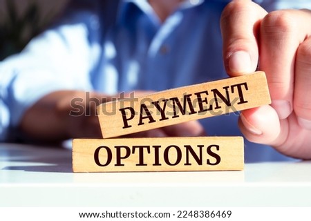 Closeup on businessman holding a wooden block with PAYMENT OPTIONS message, business concept