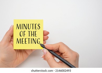 Closeup on businesswoman holding a card with text MINUTES OF THE MEETING, business concept image