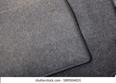Close-up on a car floor mat in the back of a minivan made of black carpet on a white isolated background. Auto service industry. Spare parts catalog.