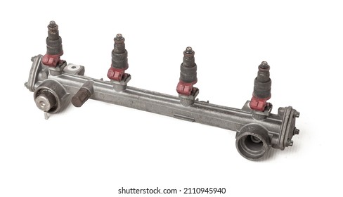 Close-up On A Car Fuel Rail With Injectors For Supplying Gasoline To A Four Cylinder Engine On A White Isolated Background. Spare Parts Catalog.