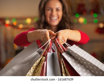 Closeup on christmas shopping bags in hand of smiling young woman