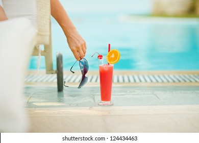 Closeup on cocktail near chaise-longue with relaxing woman - Powered by Shutterstock