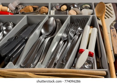 Close-up On On The Contents Of A Kitchen Drawer Full Of Cutlery And Utensils