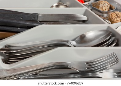 Close-up On On The Contents Of A Kitchen Drawer Full Of Cutlery And A Few Corks