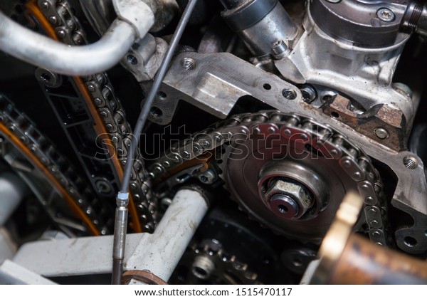 Close-up on a disassembled engine with a view\
of the gas distribution mechanism, chain, gears and tensioners\
during repair and restoration after a breakdown. Auto service\
industry.