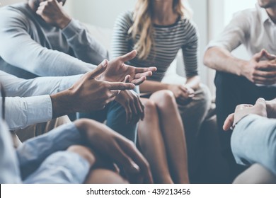 Close-up on discussion. Close-up of people communicating while sitting in circle and gesturing  - Shutterstock ID 439213456