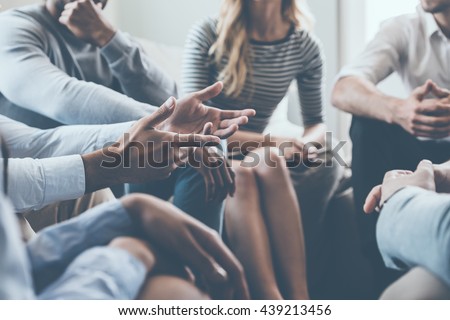 Close-up on discussion. Close-up of people communicating while sitting in circle and gesturing 