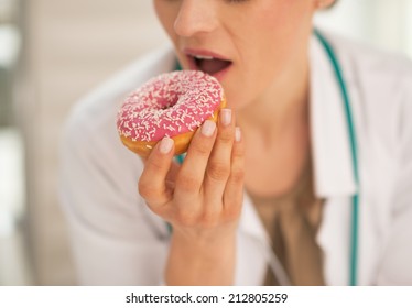 Closeup On Doctor Woman Biting Donut