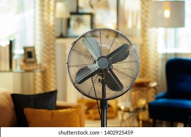 Крупный план электрического напольного вентилятора в современной гостиной в солнечный жаркий летний день.