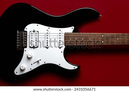 Close-up on electric guitar over red background