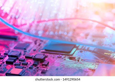 Closeup on electronic board and neon electric lights, blurred and toned electronic background in pink, blue and purple