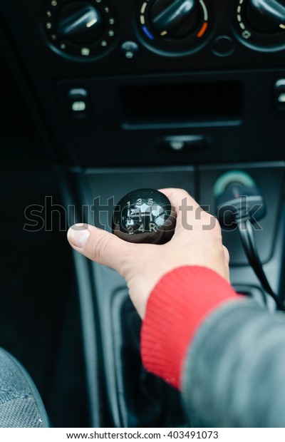 Closeup on female hand changing levels of\
mechanic car gearbox, black\
background