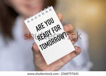Closeup on Female holding a card with text ARE YOU READY FOR TOMORROW, business concept image with soft focus background and vintage tone