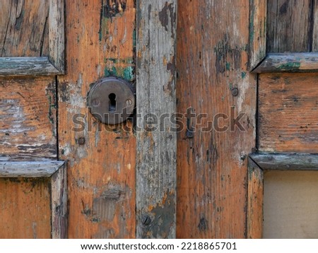 close-up on a fragment of a wooden door with strips, escutcheons and a keyhole