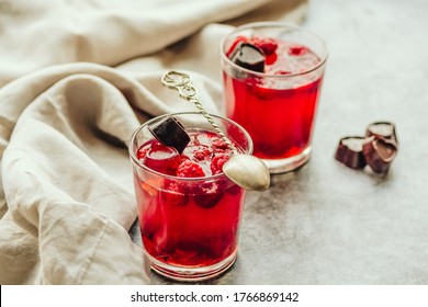 Close-up on glass cup berry fruit jelly pudding with fresh raspberries - summer dessert  in glasses on gray background. Diet dessert concept.