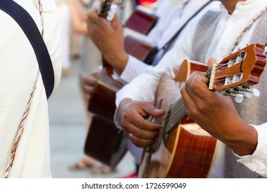 Closeup on guitar players wearing local costumes in Las Palmas, Spain. Music band on traditional clothes playing instruments on special event. Musicians on party celebration in Canary Islands