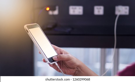 Close-up On Hand Holding Phone Showing White Screen At Free Charging Station.