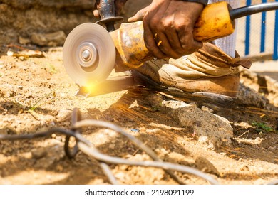 Closeup On The Hand Of A Latin Man Cutting A Metal Bar With A Circular Electric Hand Saw