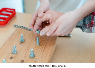 Closeup on hand of man in occupational therapy screwing nut on bolt - Shutterstock ID 1897190140