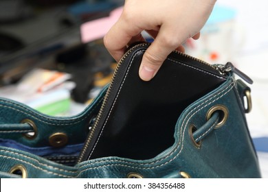 Close-up On  Hand Pickpocketing A Purse In A Woman Bag