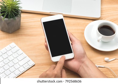 Close-up on hand using phone. Smartphone mock up template on office desk. - Shutterstock ID 792568636