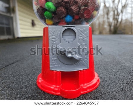 A closeup on the handle of a candy machine where coins are put into it to get the candy out.