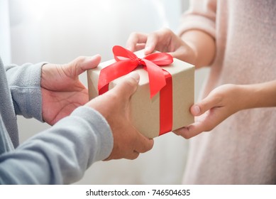 Closeup On Hands. Asian Woman Giving A Brown Gift Box To Elderly Or Old Man For Birthday, Christmas And New Year On White Background. Family Lifestyle, Father Day, Holiday Celebration.