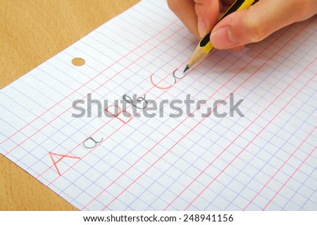 Closeup on the hands of a child doing writing activity as part of homework. School concept