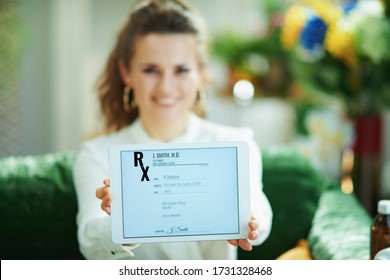 Closeup on happy woman at home in sunny day showing electronic prescription on a tablet PC. Foto Stock