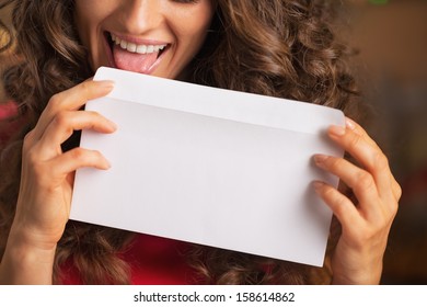 Closeup On Happy Young Woman Licking Envelope