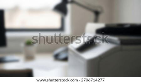 Close-up on a modern multifunction printer on a bright office desk.