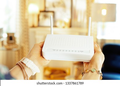 Closeup On Modern Wifi Router With 2 Antennas In Hand Of Modern Woman In The Living Room.