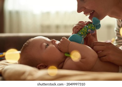 Closeup On Mother Giving Baby Blue Soft Toy To Stimulate Tactile And Visual Senses. Early Development Toys. Baby Putting Toy Into Mouth.