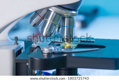 Close-up on oculars and slide glass of Light or fluorescent stereo microscope in research laboratory environment or histopathology training class for medics, student or scholars in biology class.