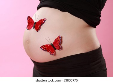 Closeup On Pregnant Woman Belly With Fake Red Butterflies