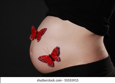 Closeup On Pregnant Woman Belly With Fake Red Butterflies