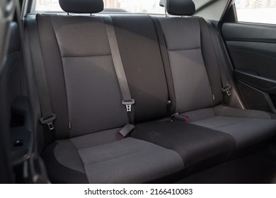 Close-up on rear seats with velours fabric upholstery in the interior of an old Korean car in gray after dry cleaning. Auto service industry.