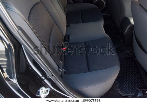 Close-up on rear seats with velours fabric\
upholstery in the interior of an old Japan car in gray after dry\
cleaning. Auto service\
industry.