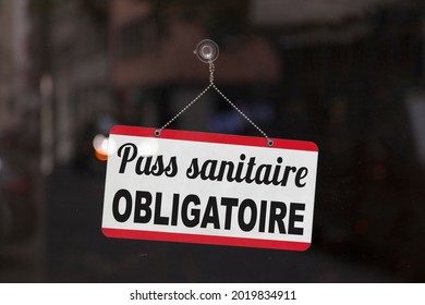 Close-up on a red and white sign in a window with written in French "Pass sanitaire obligatoire", meaning in English "Compulsory health pass". - Shutterstock ID 2019834911