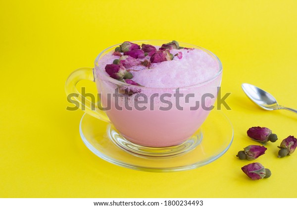 Closeup on rose moon milk in glass cup on the\
yellow surface