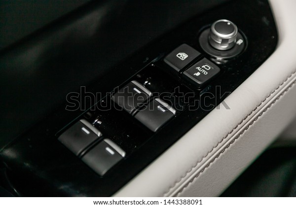 Close-up on the side door lock and glass control\
buttons,  automatic adjust level dashboard. modern car interior:\
parts, buttons, knobs