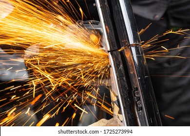 Close-up on the sides fly bright sparks from the angle grinder machine. A young male welder  grinds a metal product with angle grinder in the garage - Powered by Shutterstock