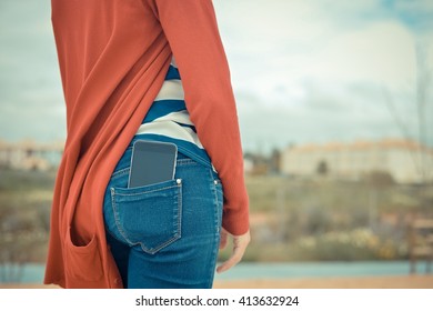 Closeup on smartphone in the back pocket of a womans jeans, blank screen with clipping path for you to add your own message or design