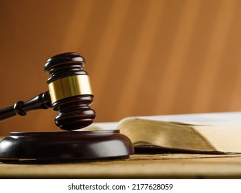 Close-up. On The Table Is An Open Book And A Judge's Wooden Gavel. Symbols Of A Fair Trial. Rule Of Law, Constitution, Democracy. Banner, Poster. There Are No People In The Photo.