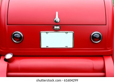 Closeup On Trunk Of A Red Antique Car And License Plate