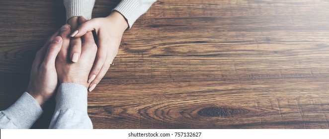 Closeup on two young lovers holding hands at a table - Shutterstock ID 757132627