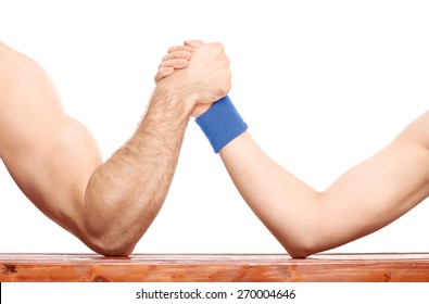 Close-up on an uneven arm wrestling contest between a muscular arm and a skinny one isolated on white background