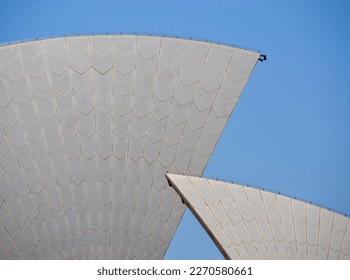 Closeup on the white tiled sails of the iconic opera house in Sydney against a clear blue sky