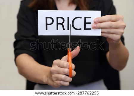 Closeup on woman cutting paper of price word